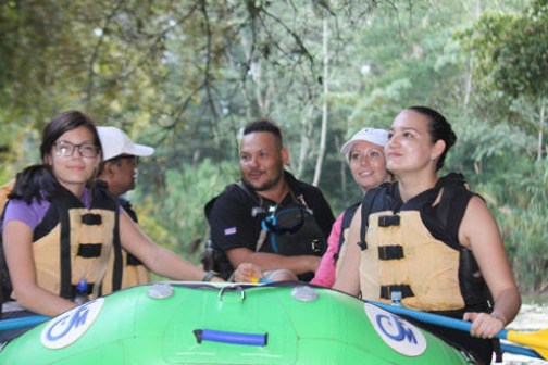 small group of people standing by green raft